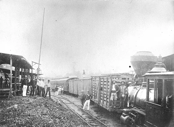 The Chimbo train station, with locals posing next to the train cars and the locomotive