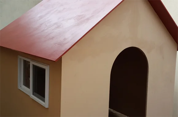 Casa de juegos pintada con techo rojo y paredes color beige